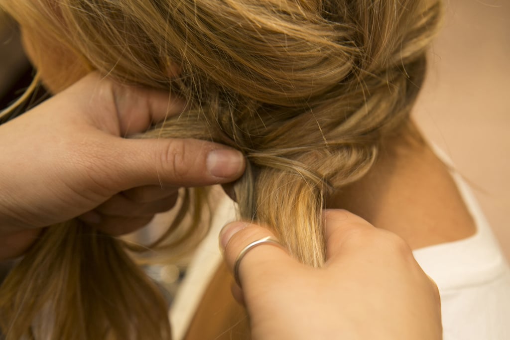 Once you've braided the hair, it should meet with the original twist behind your ear. Gather the hair into one section and start to fishtail-braid the hair (close-up and how-to on next slide). If you're not a pro yet, Guillen recommends securing with an elastic before you start braiding, and then cut the elastic once you've completed your braid.