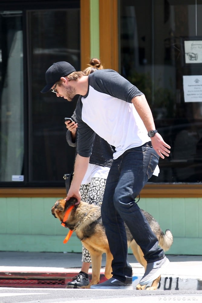 Liam Hemsworth bent down to show a furry friend some love in LA in May 2012.