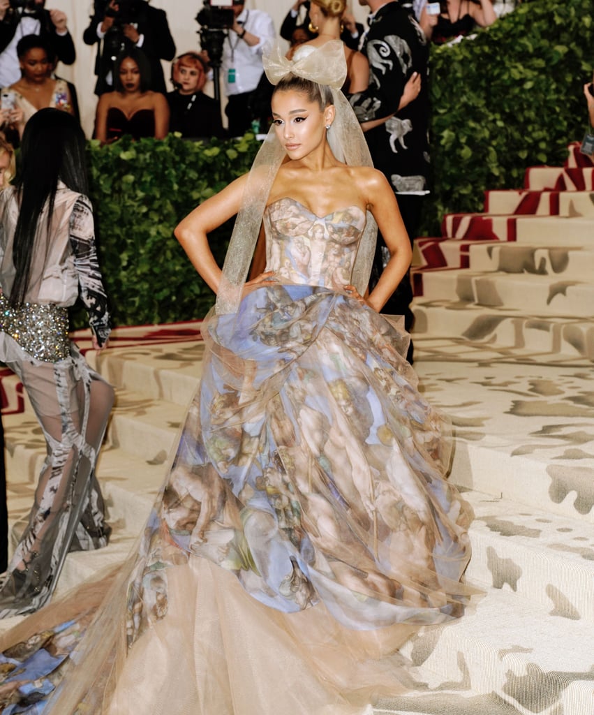 At the May 7 Met Gala, Ariana accompanied Vera Wang in a watercolor strapless gown the designer created. Appropriate for the event's "Heavenly Bodies" theme, the piece was painted with Michelangelo's "The Last Judgment" scene, which covers the altar wall of the Sistine Chapel in Vatican City. Ariana's momentous look was finished with a large tulle bow and Butani jewels.