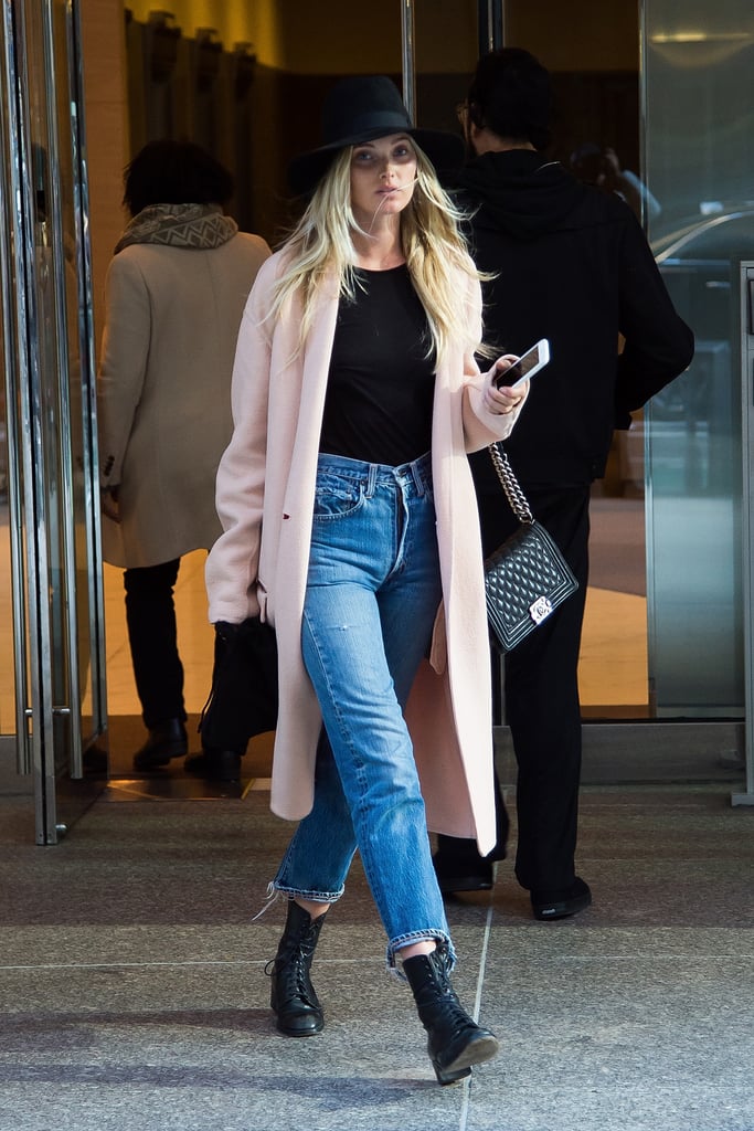 Elsa Hosk spotted out in NYC wearing an on-trend pale pink coat and model-off-duty staples: cozy denim and black accessories.