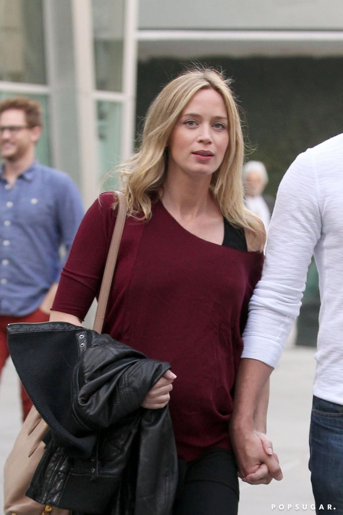 Emily covered her baby bump with a loose shirt.
