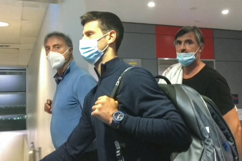 This screen grab from AFPTV shows Serbia's Novak Djokovic (C) walking ahead of his coach Goran Ivanisevic (R) after they disembarked from their plane at the airport in Dubai on January 17, 2022, after losing a legal battle on January 16 in Australia to st
