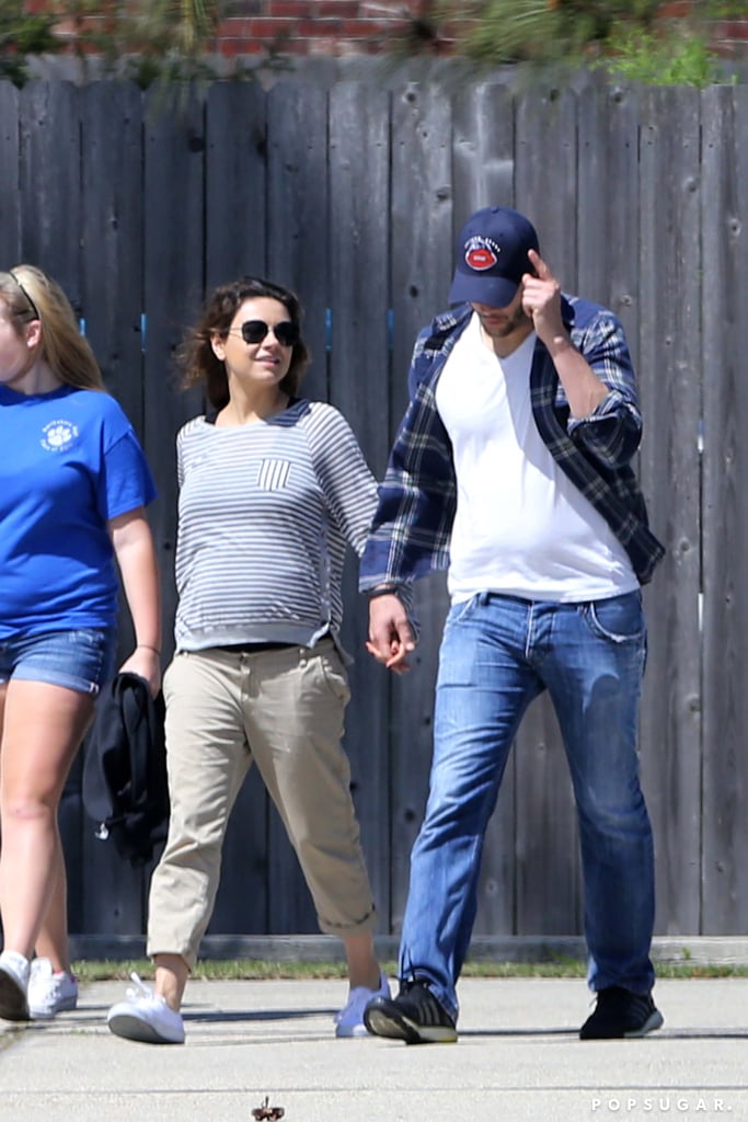 Mila Kunis Shows Baby Bump at Airport With Ashton Kutcher
