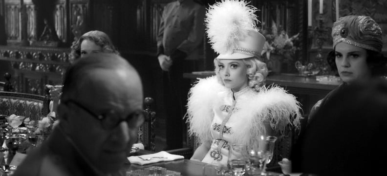 MANK, Arliss Howard (glasses) as Louis B. Mayer, Amanda Seyfried (in white) as Marion Davies, 2020.  Netflix / Courtesy Everett Collection