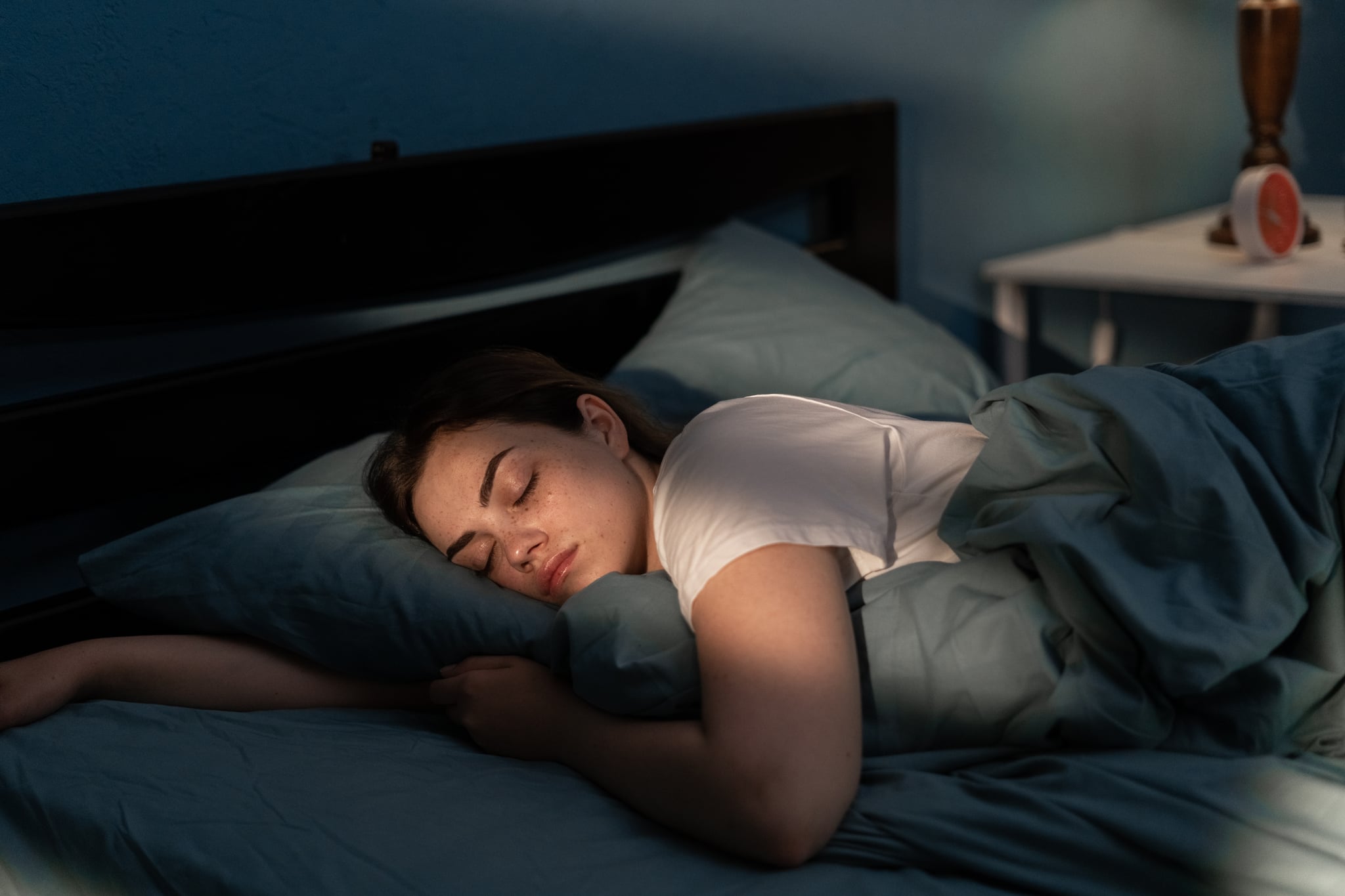 Young woman sleeping in bed. Pregnancy dreams.