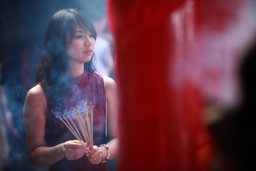 In Bali, a woman carried incense during prayers.