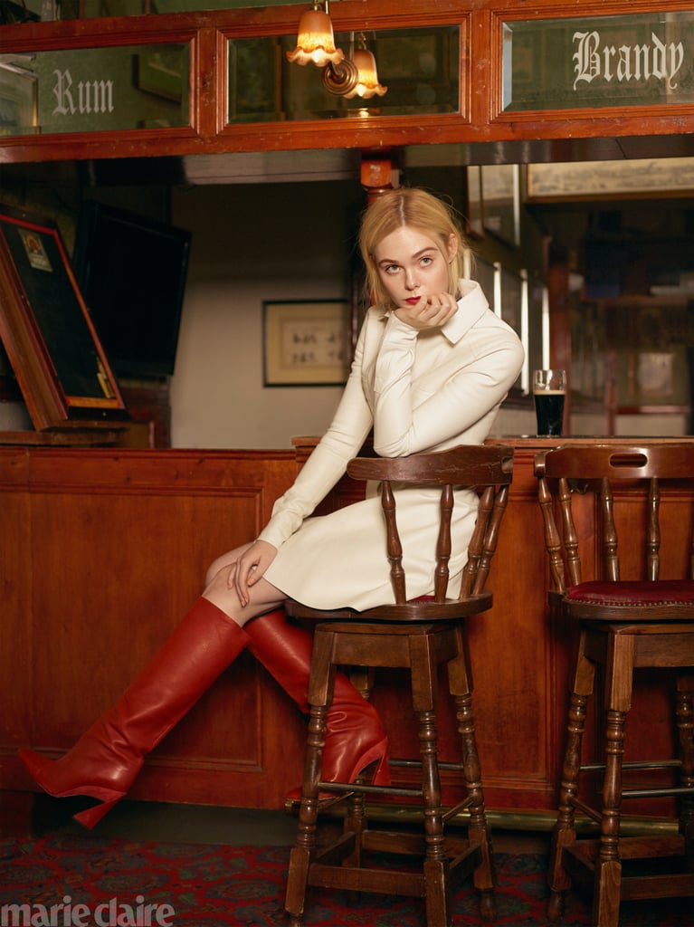 Elle Fanning wearing a Longchamp dress and Salvatore Ferragamo boots.