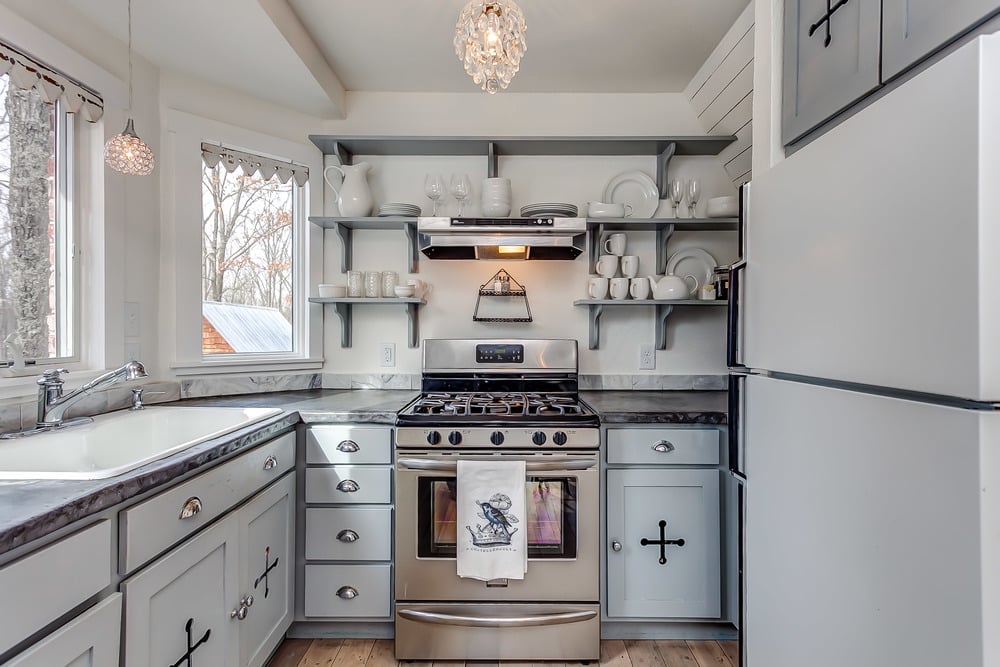 The kitchen is the perfect mix of function and beauty. Love the open shelves filled with white china!