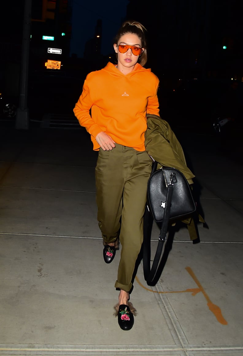 Gigi Styled Her Gucci Loafers With Satin Green Pants, an Orange Hoodie, and Matching Sunglasses