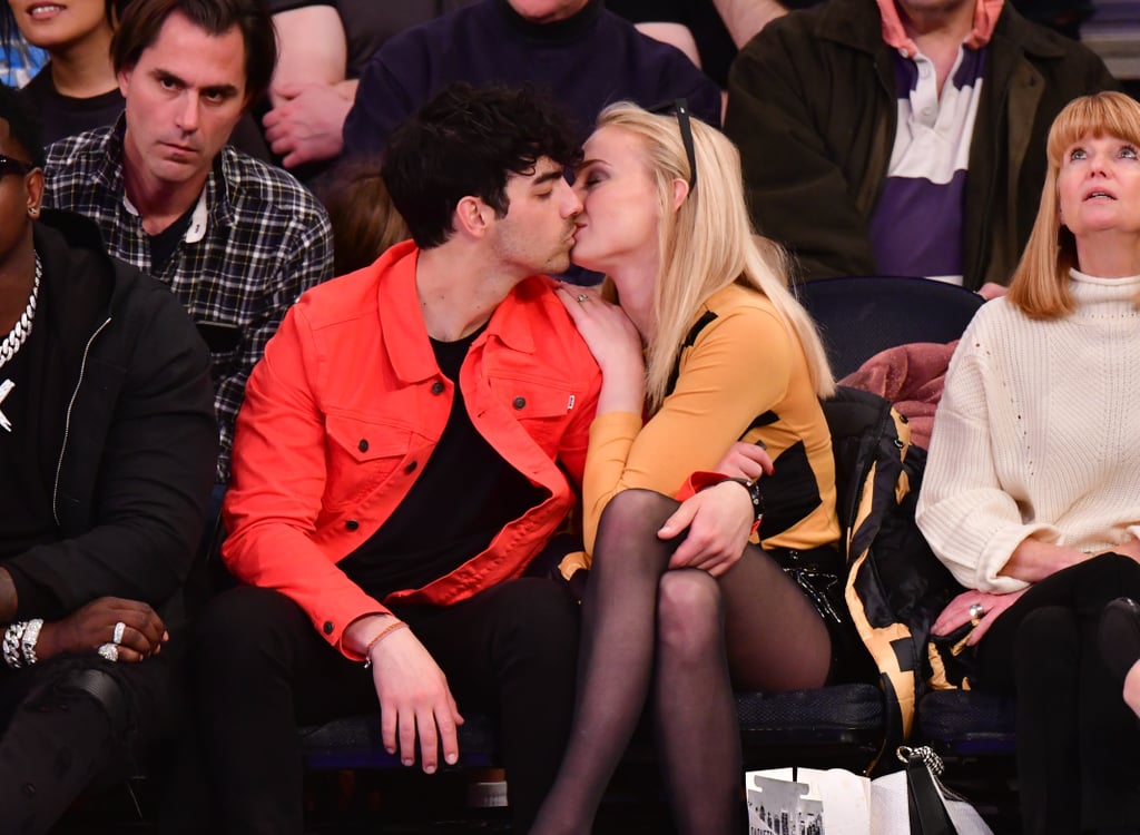 Following the Jonas Brothers' recent reunion, Joe Jonas celebrated by having a cozy date night with his fiancée, Sophie Turner. On Saturday, the couple sat courtside with Sophie's parents as they watched the Sacramento Kings take on the New York Knicks at Madison Square Garden. The two looked lost in their own little world as they cuddled up and shared a few kisses. At one point, the Game of Thrones actress playfully offered her sucker candy to Joe. 
Their sickeningly sweet appearance comes just after Sophie's special appearance in the Jonas Brothers' "Sucker" music video. In the video, the brothers are joined by their real-life partners as they sing about being "suckers" in love. Joe and Sophie got engaged in October 2017 and are planning on tying the knot later this year. During the Jonas Brothers' appearance on The Late Late Show, Joe revealed that they will be having a Summer wedding.