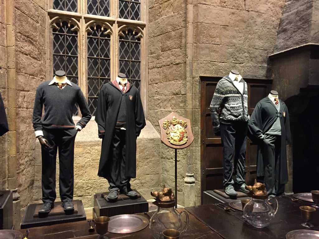 There are costumes displayed throughout the room, including these Gryffindor uniforms.