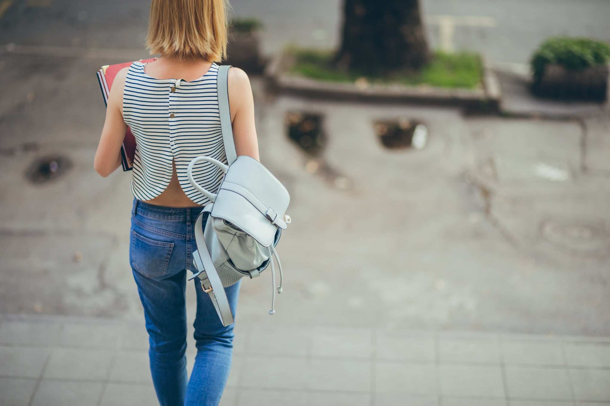 Young female college student going down the stairs