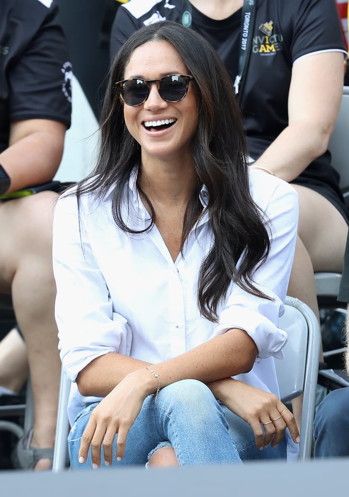 Her penchant for the style dates back to her and Prince Harry's first public appearance as a couple at the Invictus Games in 2017, where she wore Misha's Husband Shirt with a pair of distressed skinny jeans. Since then, Markle has worn similar styles on numerous occasions, from casual outings to Zoom meetings.