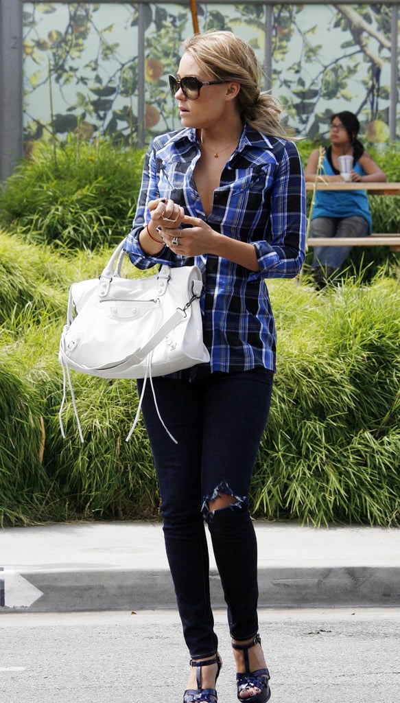 Styling a plaid shirt with distressed denim and a Balenciaga bag in 2008.