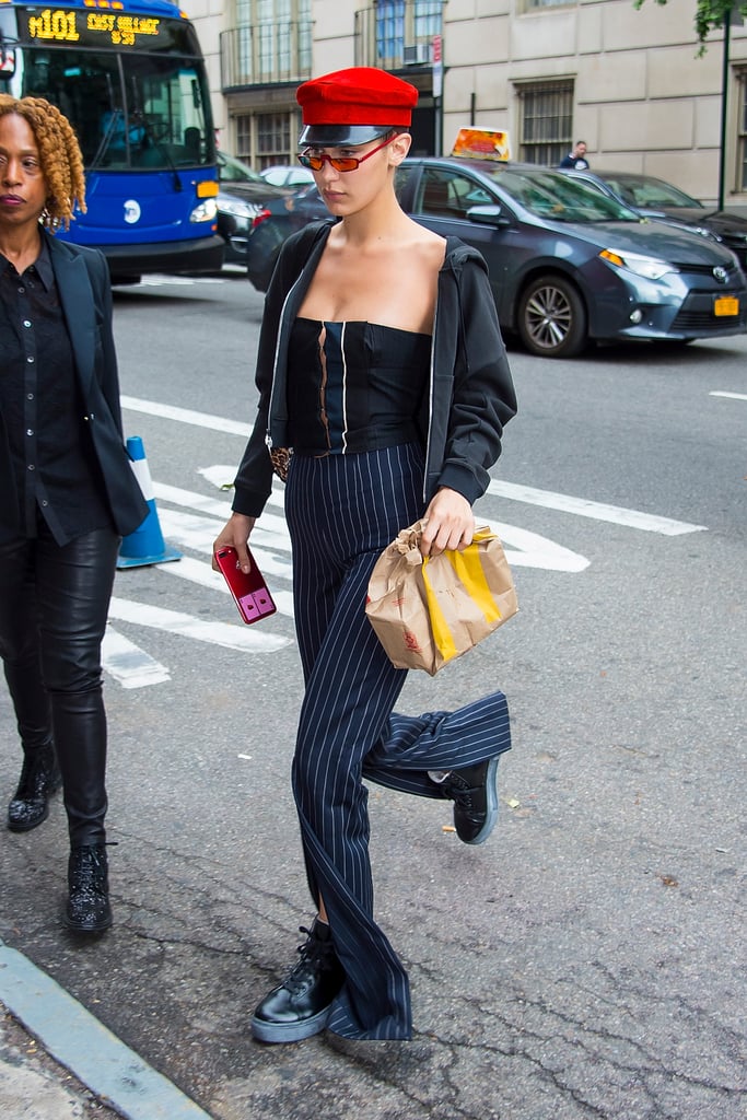 Bella Hadid wore a pair of sneaker combat boots with striped pants and a newsboy cap.