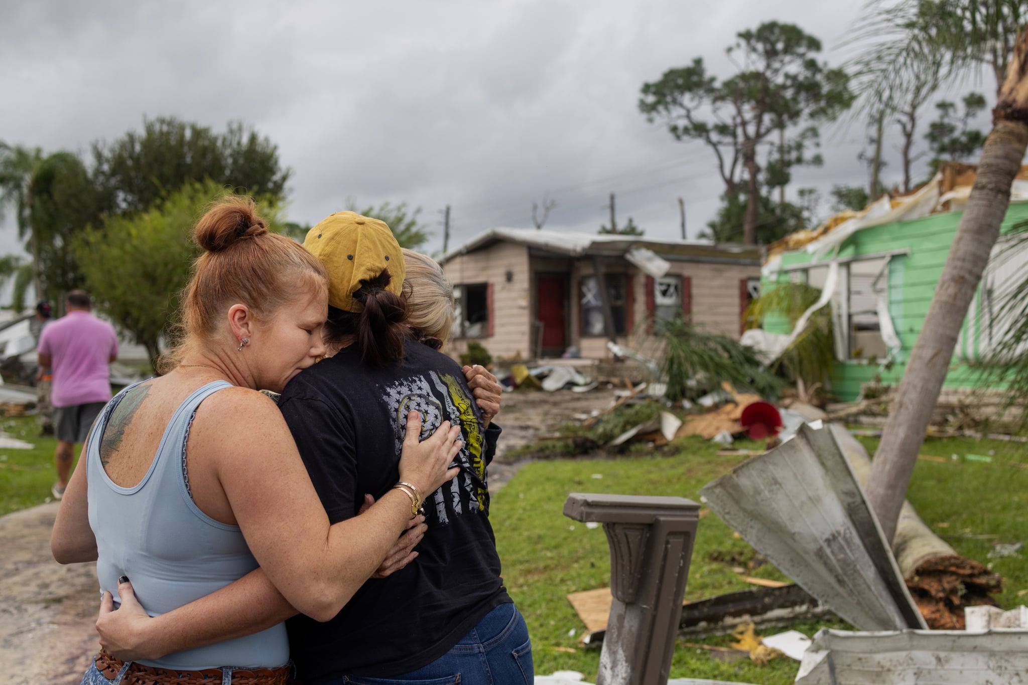Summer Capito, of Vero Beach, embraces her sister Savannah Rath, right, of Palm Bay, and their mother Tracy Carter after arriving to Tracy's home which had been destroyed by a tornado spawned in the outer bands of Hurricane Milton.