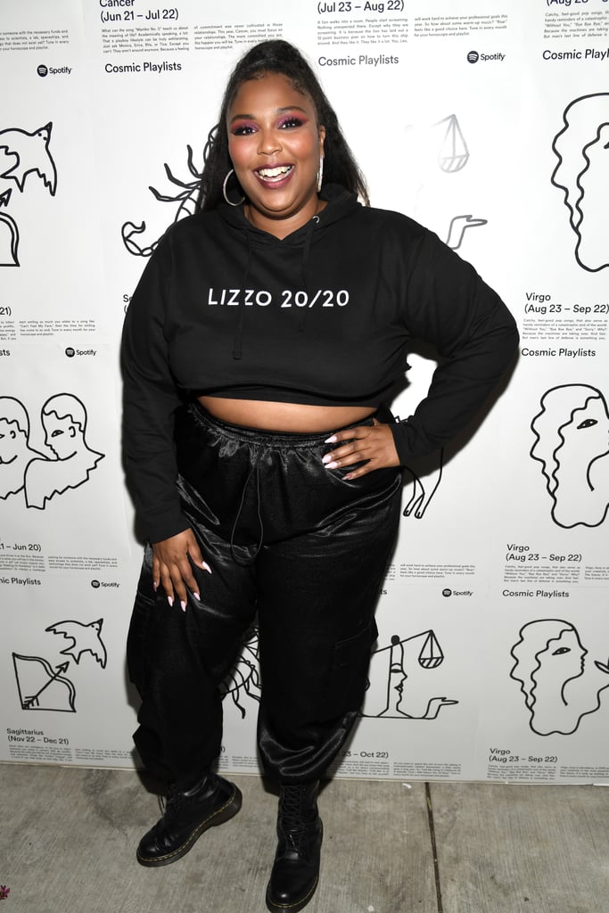 Of course, Lizzo looks amazing in her own merch. She pair cropped Lizzo 20/20 hoodie with classic Dr. Marten's combat boots and a pair of shimmery black sweats.