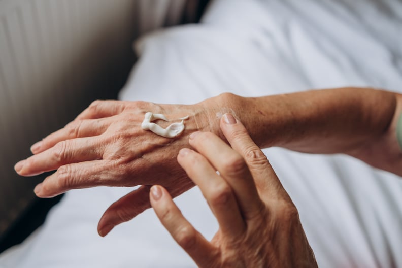 women senior takes care of herselfhand carewoman applying cream to her hands