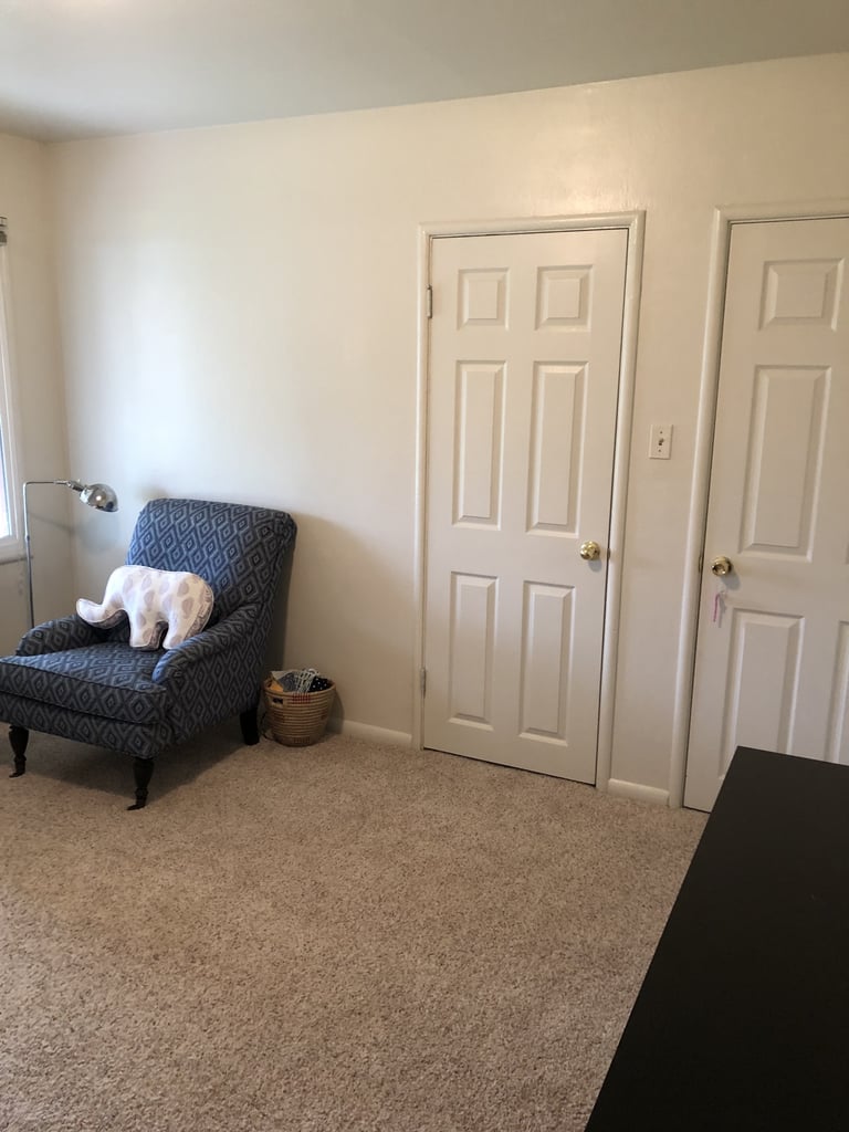A chair, floor lamp, and small basket occupied the wall space next to the closet door.