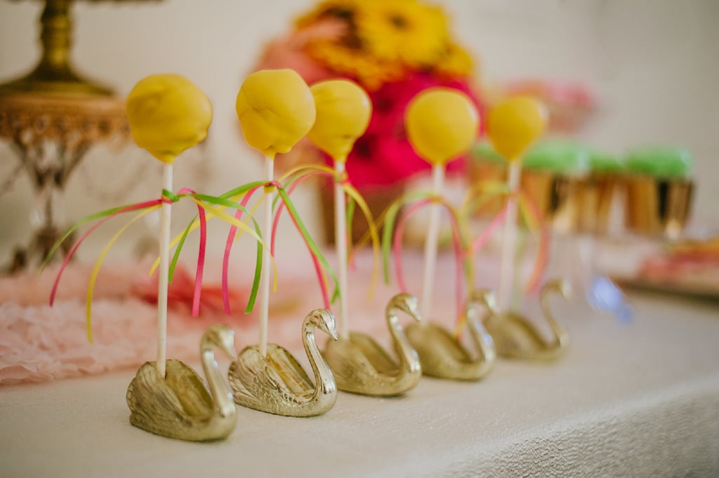 Cake pops were placed in swan cigar holders on the dessert table.