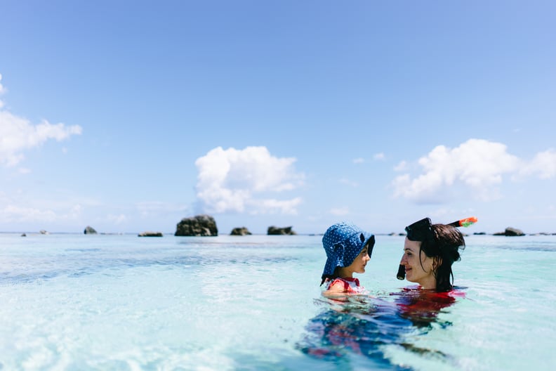 Mother and 3 year old toddler girl having intimate moment in clear tropical water, Amami Gunto National Park, Kagoshima, Japan