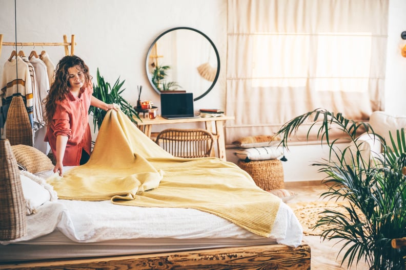 woman making her bed at home