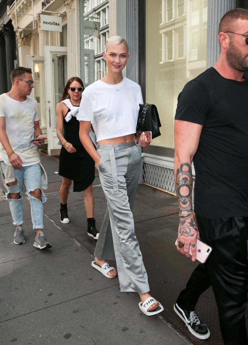 Karlie Was Seen Wearing Gray Silk Trousers and a White Crop Top