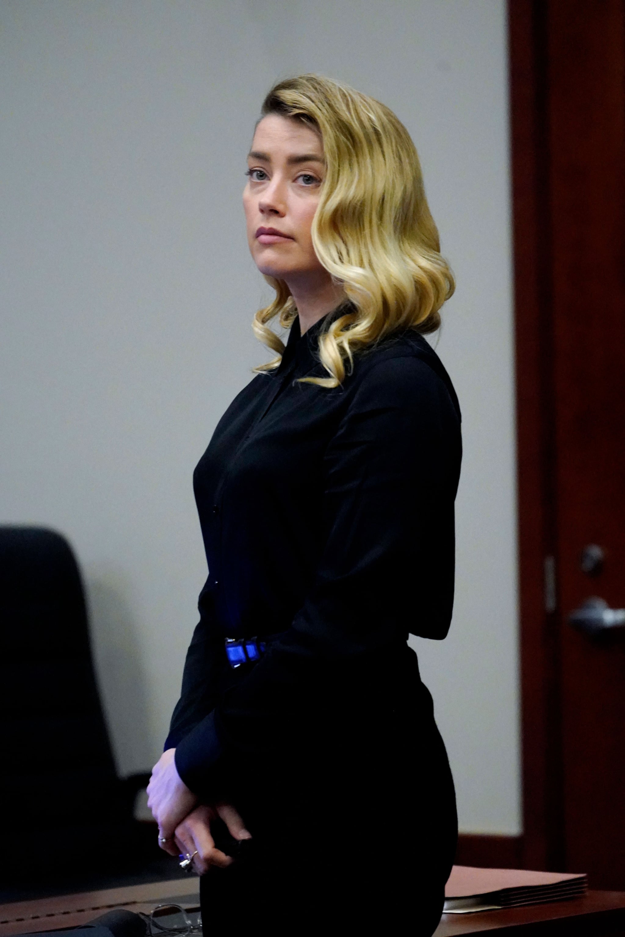 US actress Amber Heard stands and watches the jury leave as a lunch break starts at the Fairfax County Circuit Court in Fairfax, Virginia, on April 18, 2022. - US actor Johnny Depp sued his ex-wife Amber Heard for libel in Fairfax County Circuit Court after she wrote an op-ed piece in The Washington Post in 2018 referring to herself as a public figure representing domestic abuse. (Photo by Steve Helber / POOL / AFP) (Photo by STEVE HELBER/POOL/AFP via Getty Images)