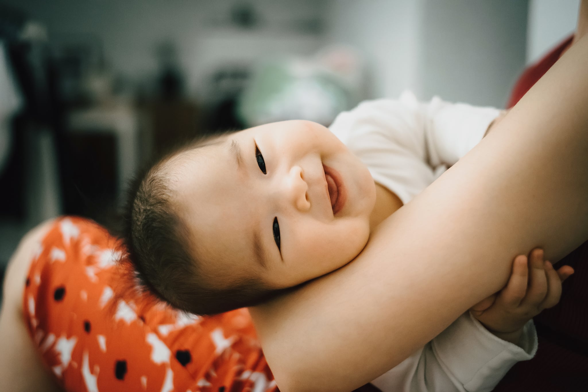 Mother embracing smiling cute baby in her arms