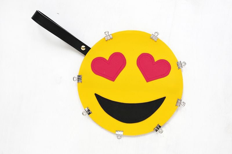 Once the cutouts are in place, use the glue to attach the front circle to the back circle (wrong sides facing each other), and glue the end of the handle loop between the two layers to secure. Use binder clips to keep the edges together as the glue sets.