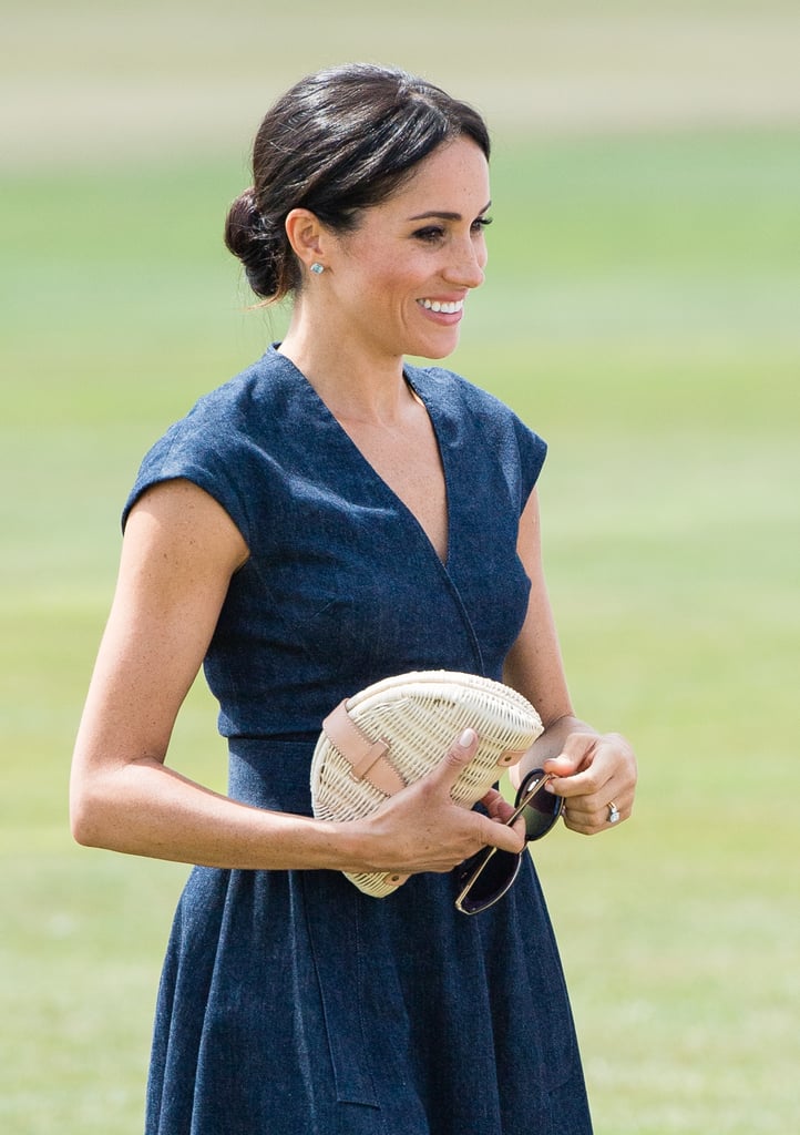Meghan accessorized her denim Carolina Herrera dress with a raffia J.Crew clutch at the Sentebale Polo match in Windsor in 2018.