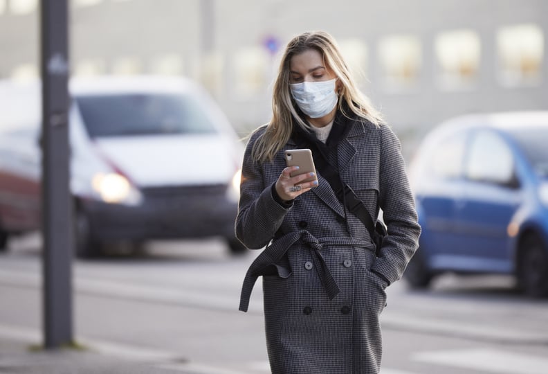 woman wearing mask outside amid tripledemic of covid, rsv, and flu
