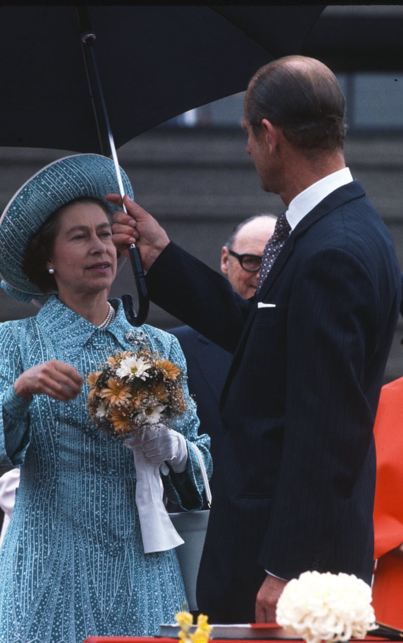 Prince Philip holds an umbrella for Queen Elizabeth II in Canada in 1976.