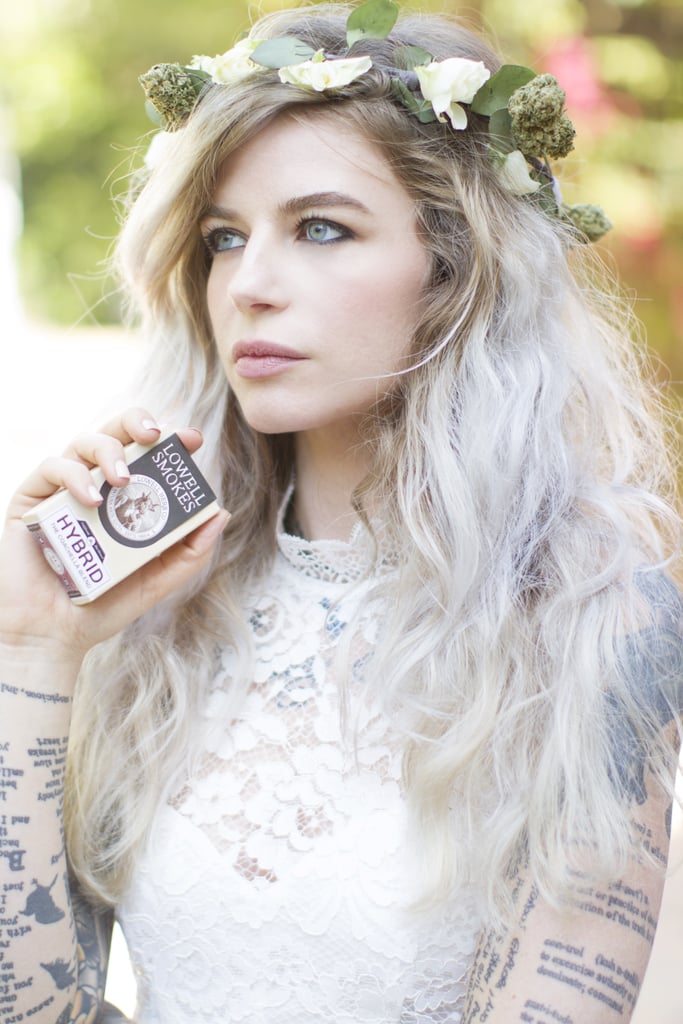 Whether you're hoping to have the chillest music festival season of all time or are looking to celebrate 4/20 in style, organic cannabis grower Lowell Farms has a perfectly chic solution: marijuana flower crowns.  
You can snag this stylish accessory exclusively during Coachella (which begins April 14 and ends April 23, beautifully straddling April 20). It's actually not available to buy on its own, though — it's a gift with purchase. Lowell Farms is selling a limited-edition Coachella Blend of prerolled joints for $55 (which includes Dog Walker, Single White Girl, Chocolate Hashberry, and Lenny OG) at Palm Springs Safe Access Dispensary, conveniently located 15 minutes away from the music festival. The first 12 patients to pick up their preorder of their Coachella joints will receive the above white rose and weed flower crown. And yes, it's smokeable — it boasts a quarter ounce (a $60 value!) of Single White Girl cannabis.
If you're not up to date on the local marijuana consumption laws, please note that you can only buy the joints (and receive the crown) if you have a verified doctor recommendation. You also can't wear the headpiece at the music festival, so either break the stems off — the crown will look perfectly wearable without them! — or wait to rock the accessory at your next private function. Keep reading to see more shots of this dank flower crown.