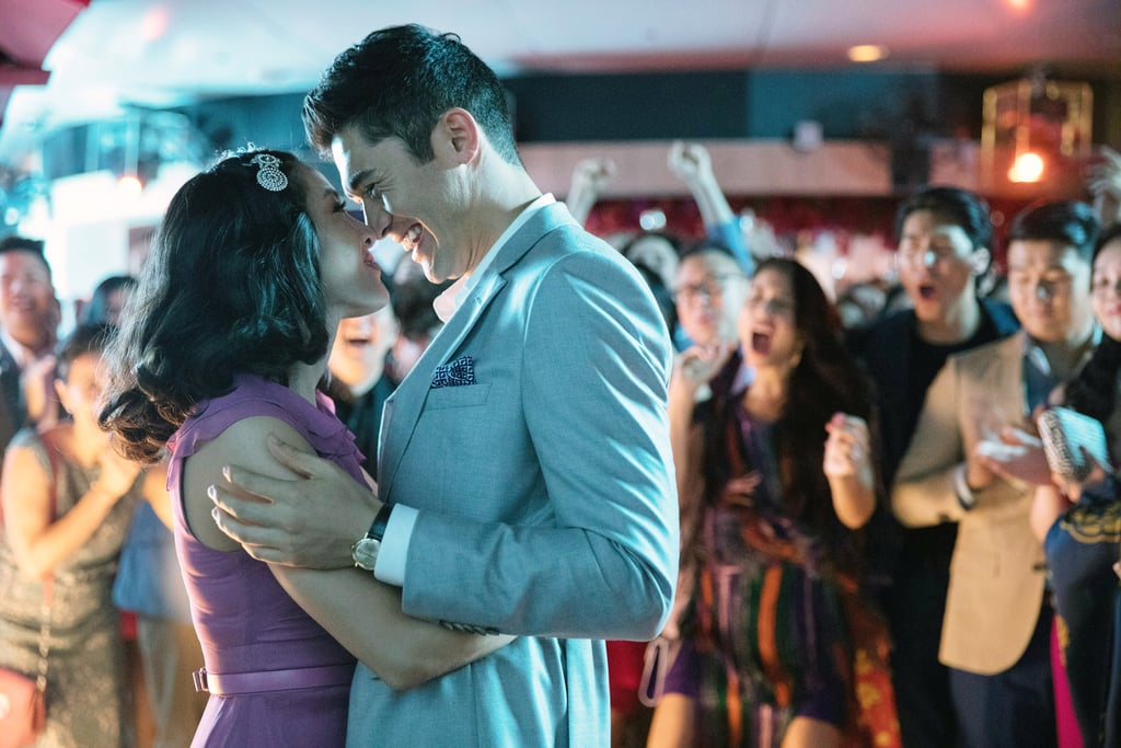 Crazy Rich Asians is a pretty perfect romantic comedy. From its unbelievably hot cast to the sweet romance at its heart — and ALL THOSE CLOTHES! — I wasn't left wanting much more after seeing the Jon Chu film. But now, months later, I feel "hustled, scammed, bamboozled, hood winked, led astray," as Ja Rule would say, since apparently we've all been denied a number of steamy sex scenes featuring Nick Young (Henry Golding) and Rachel Chu (Constance Wu). 
While chatting with Vulture at the Women in Film Oscar Party, screenwriter Adele Lim revealed the rom-com was initially heavier on the "rom," but was tweaked to be a little more PG after a few rounds of drafts on the script.
"When I did my first draft of the movie, the producers and director Jon Chu made fun of me because I had all these hot, steamy, getting-it-on scenes," Lim explained. "That's the kind of writer I am, which is true — but also, it's a bigger thing. It's a movie for women and we never see Asian men in that light. Give the people what they want! Sometimes people don't know what they want until they see it, and walking across are perfectly chiseled abs. And I'm like, yes."
Uh, Henry Golding or Pierre Png's chiseled abs? Sign me (and every other human being with working eyes and a pulse) up. In addition to Lim, the script was cowritten by Peter Chiarelli and adapted from Kevin Kwan's bestselling trilogy. So, with at least two more films in the works, can we expect to see some hotter love scenes going forward? Lim said they're "trying to work it out" for the next film, China Rich Girlfriend, and hopes things will only get sexier: 
"I want to see that across all platforms, honestly. Somebody asked me recently: Is it about objectifying Asian men? They didn't want to use the word objectify, but I said, absolutely! Because they haven't been seen in that light before. I want to see more of it! I want it out there . . . I probably had them getting more into it than taste would allow. And I'm really glad I had restraining influences in the movie pulling it back so it was appropriate for a global audience. But no, if I had it my way, [it'd be] absolutely [sexier]. You hardly see that chemistry in the media."
I only have two words for Adele Lim: HELL YEAH. (OK just kidding, I actually have two more: RIGHT ON.) So, while Warner Bros. and Jon Chu are getting the sequel together, let's all take a walk down memory lane and check out some of Rachel and Nick's romantic moments from the first film (as well as one shirtless moment that takes place with his mom in the room . . . sorry) ahead.