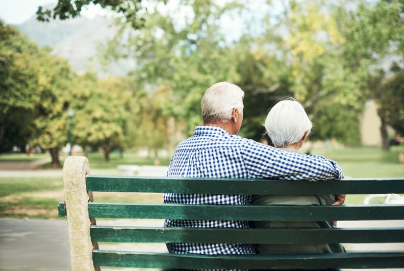 Rearview shot of a senior couple relaxing together on a park bench