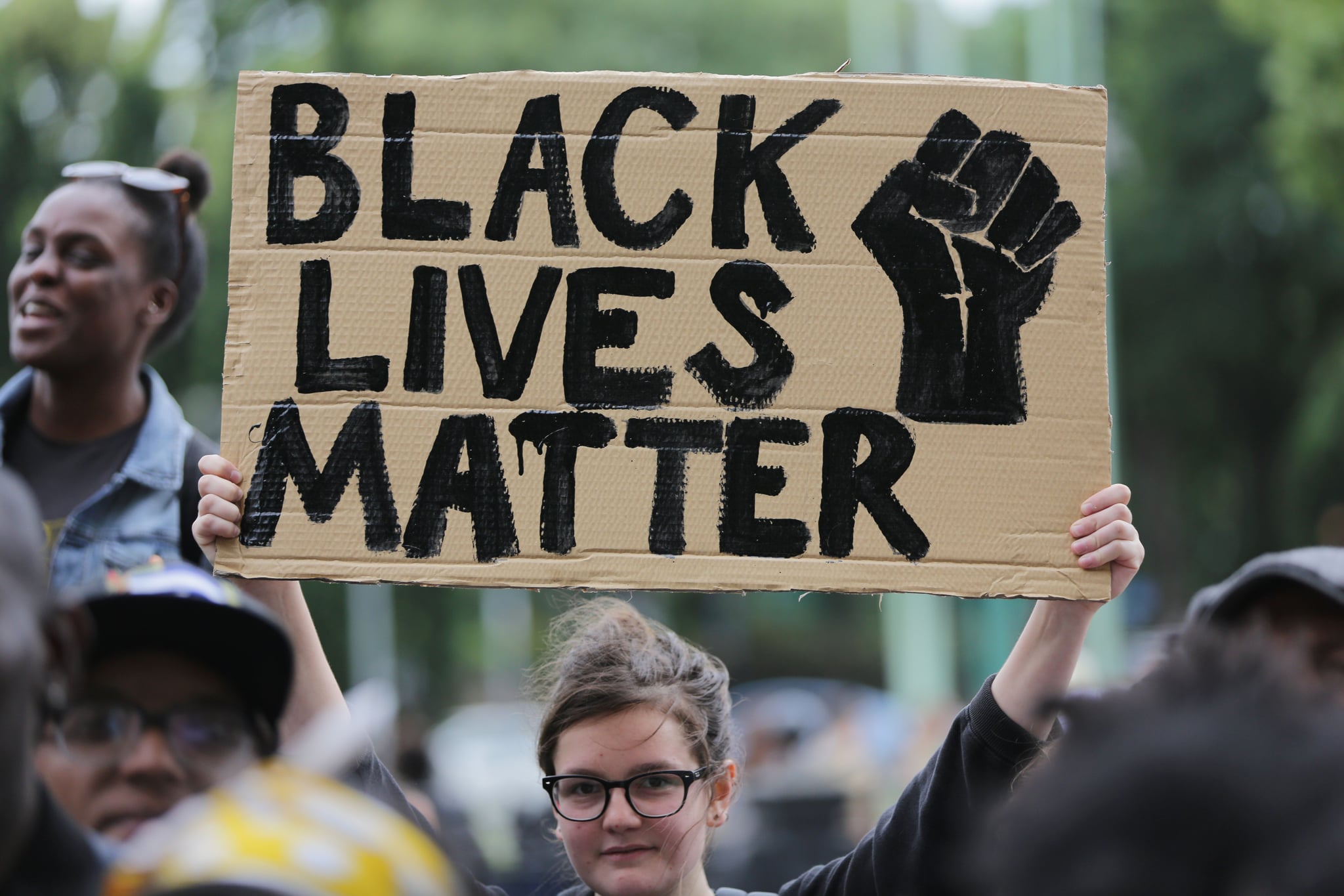 A women holds up a placard with the slogan 