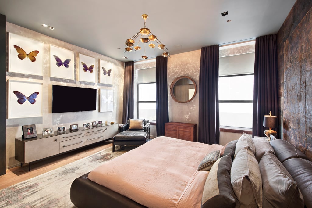 The masculine leather bed is contrasted with a wall of colorful butterfly art.