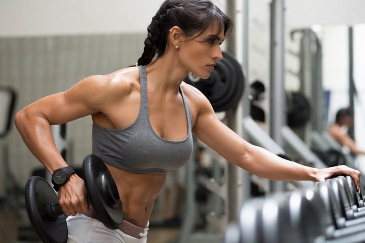 Fitness woman showing fit strong arms triceps and shoulder. Female