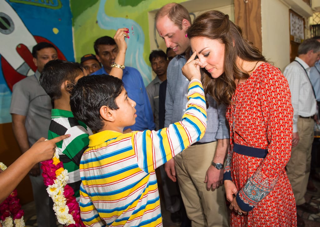 Will and Kate were greeted with a tilak by children at a charity center during their trip to India in April 2016.