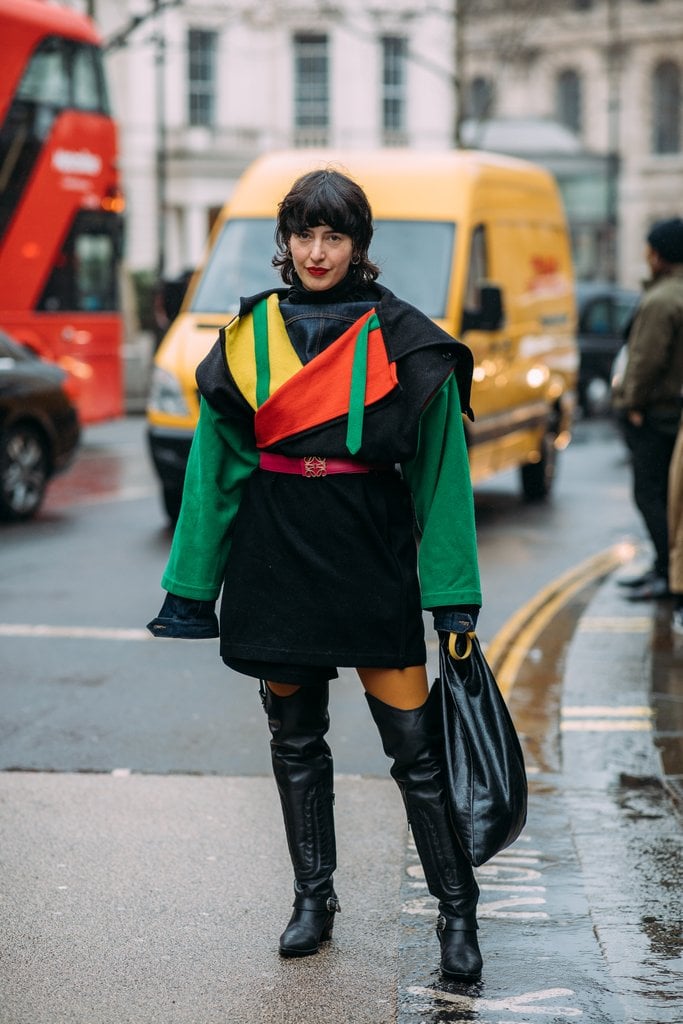A Fashion Week guest wore her rainbow coat with over-the-knee boots.