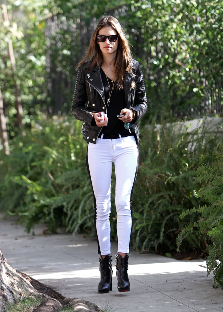 Alessandra Ambrosio kept her color palette black and white in Hudson tuxedo jeans, a black leather biker jacket, Christian Louboutin buckle booties, and Westward Leaning sunglasses during a stroll in LA.