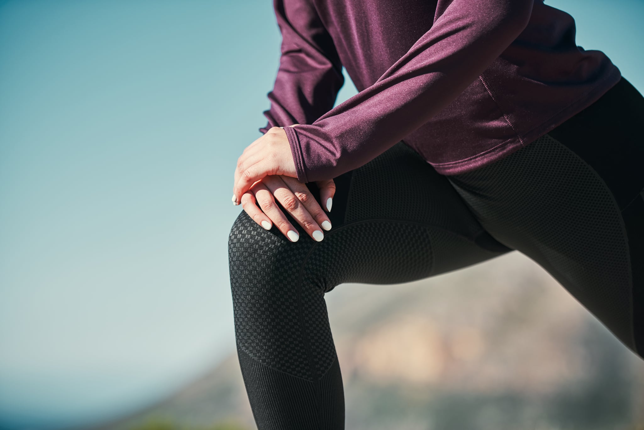 Cropped shot of a young woman stretching outdoors before her run