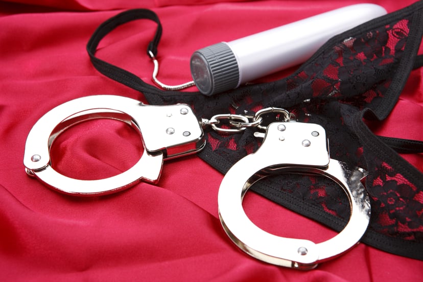 Handcuff, vibrator and thong on red satin