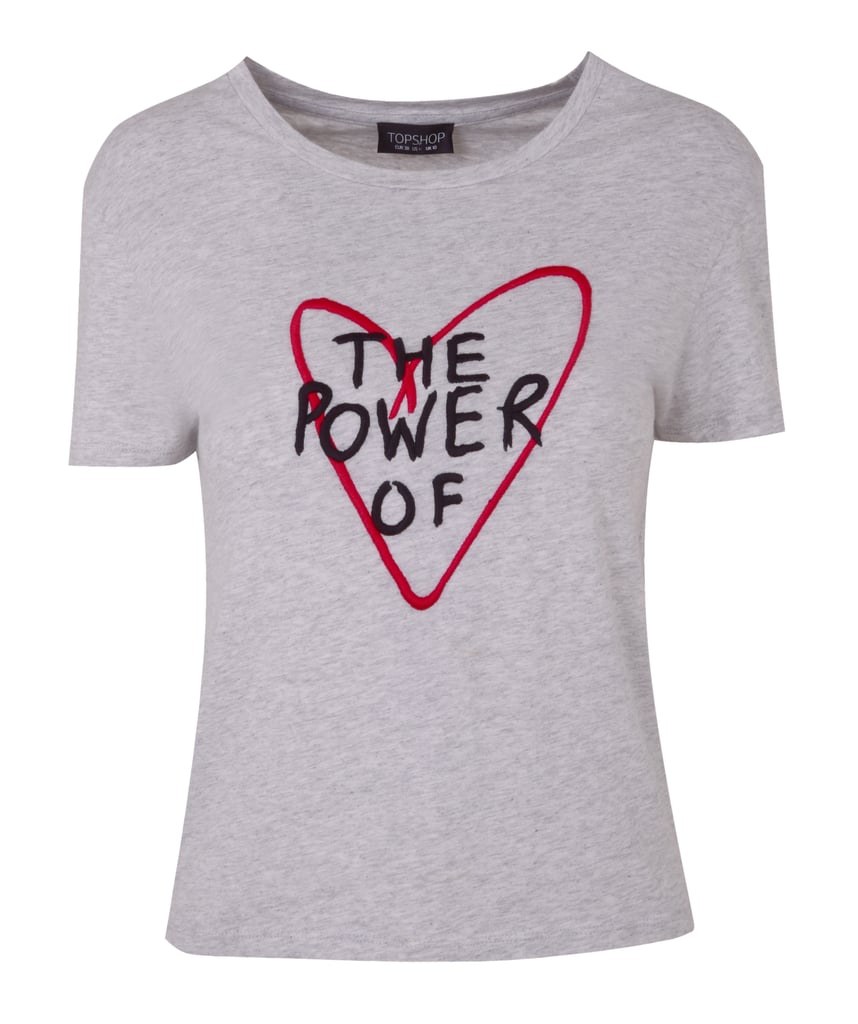 تي-شيرت يحمل عبارة "The Power of Love" – يمكنكِ شراؤه من علامة " توب شوب" (بسعر 35€ يورو؛ 159 درهماً إماراتيّاً)