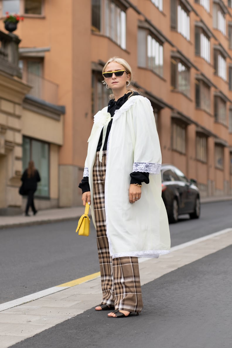 Pare down bold plaid pants with a clean white overcoat.