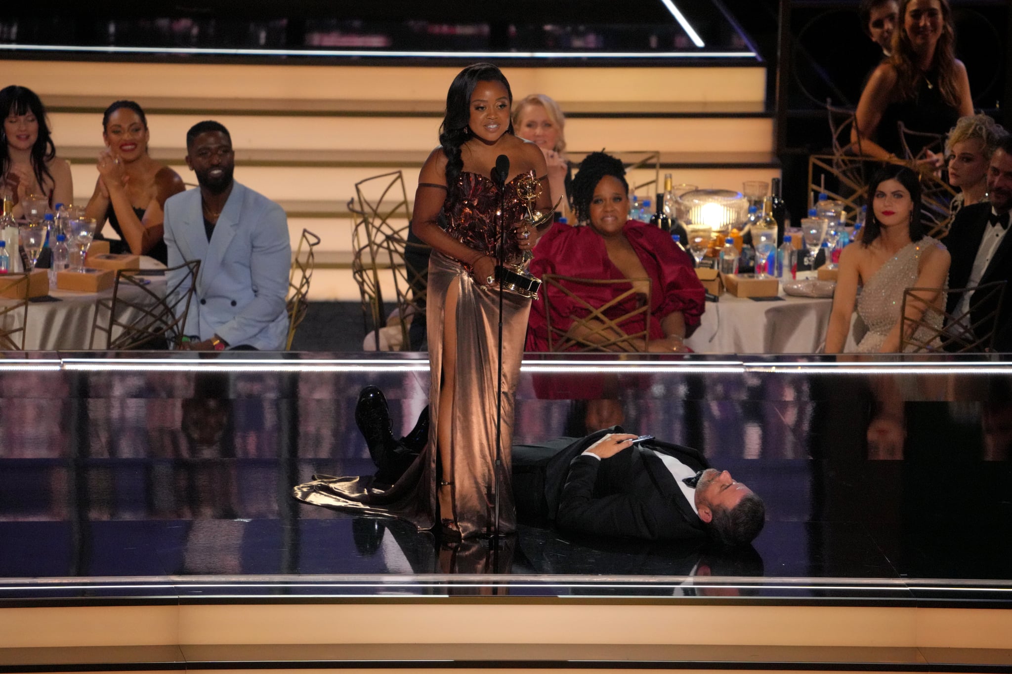 LOS ANGELES, CALIFORNIA - SEPTEMBER 12: (L-R) Quinta Brunson accepts the Outstanding Writing for a Comedy Series award for 'Abbott Elementary' from Jimmy Kimmel onstage during the 74th Primetime Emmys at Microsoft Theatre on September 12, 2022 in Los Angeles, California. (Photo by Kevin Mazur/WireImage)