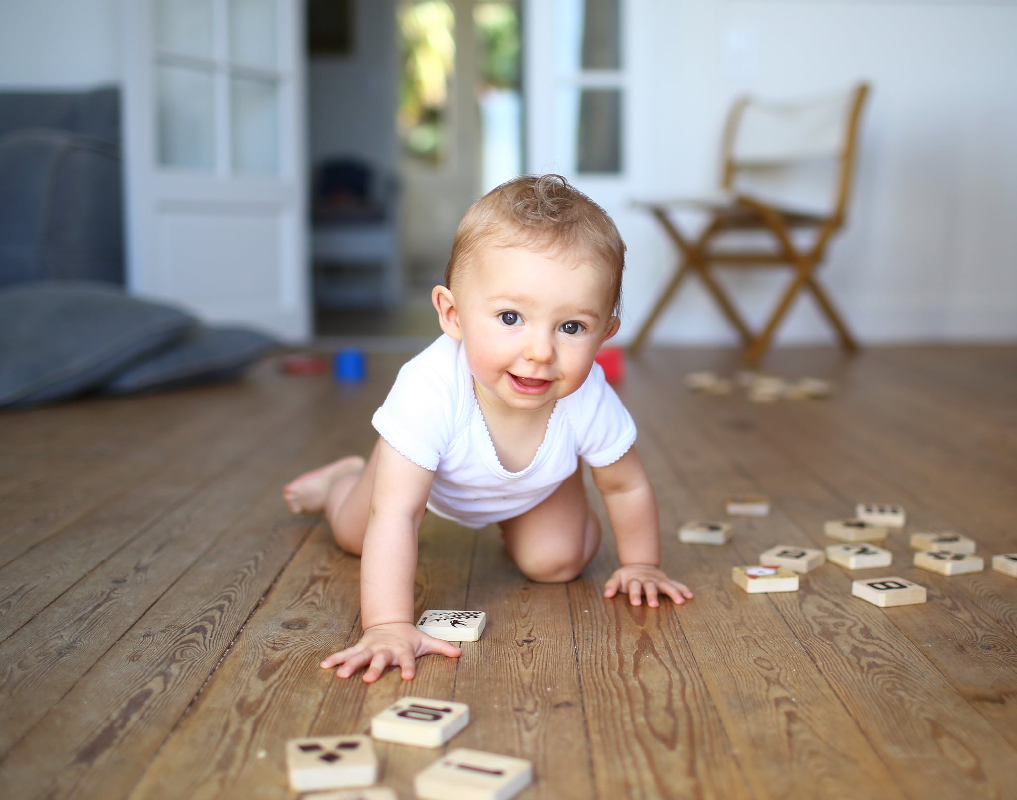 Baby crawling near letter blocks