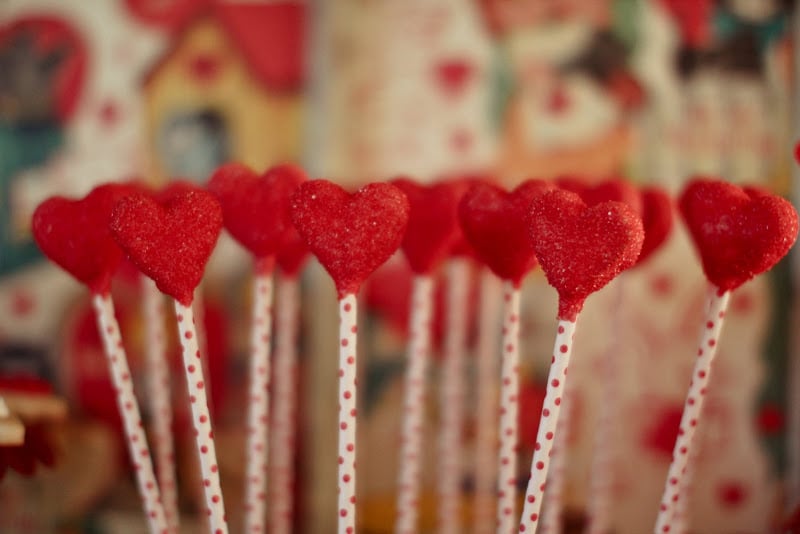 Candy-heart pops with a red polka-dot stem served as both decor and a sweet treat. 
Source: Jenny Cookies