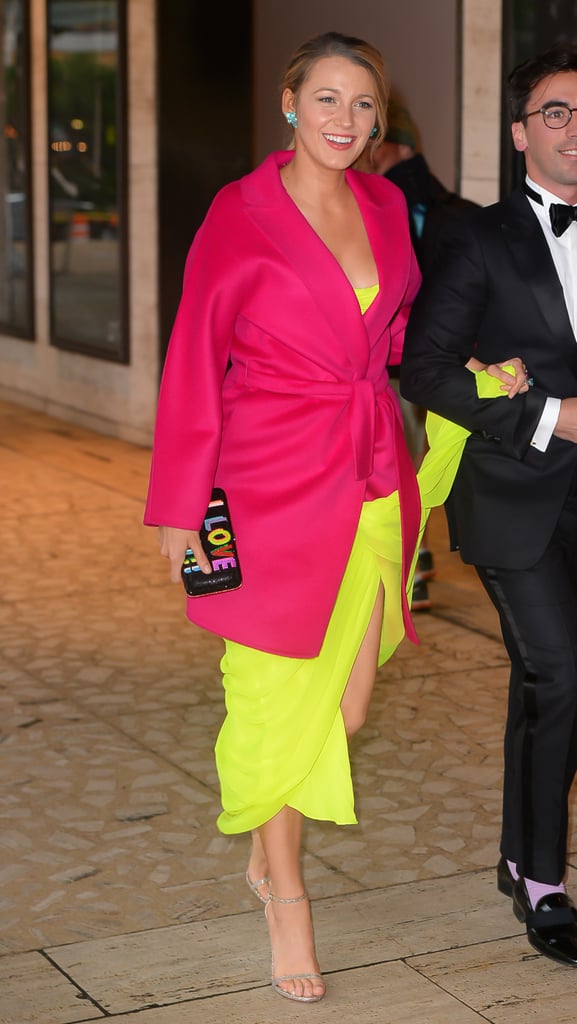 When you're Blake Lively, a black-tie event does not mean you need to wear a black dress. In fact, the stunning mom of two did the exact opposite while attending the American Ballet Theatre's Spring Gala in New York City, electrifying the red carpet in a neon yellow Oscar de la Renta gown from the Spring/Summer 2017 collection. The strapless dress featured a peaked neckline and a thigh-high slit that revealed her glittery Stuart Weitzman Nudist Sandals. 
But Blake's illuminating ensemble did not stop there. She covered up with a Gucci Fuchsia Wool Wrap Coat, immediately reminding us that neon can be paired together and look timelessly chic (even if our college days of neon parties are long behind us). Blake tied the look together with a bedazzled clutch that read "I Love You!!" in rainbow letters on one side and "Beat It!!" in red on the other side.
Keep reading to see more photos of Blake's bright outfit and make sure you check out her mixed-message clutch.